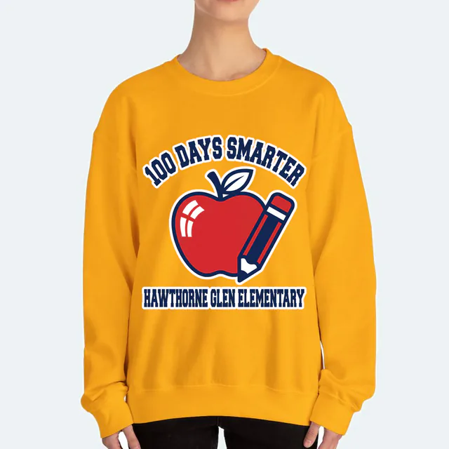 A varsity arch over an apple, 100 DAYS SMARTER, on a gold adult crewneck