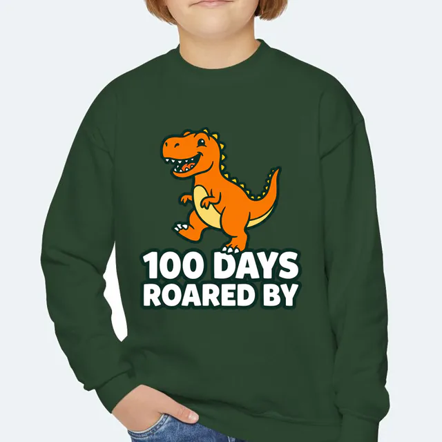 A proud stomping dinosaur, 100 DAYS ROARED BY, on a forest green youth crewneck
