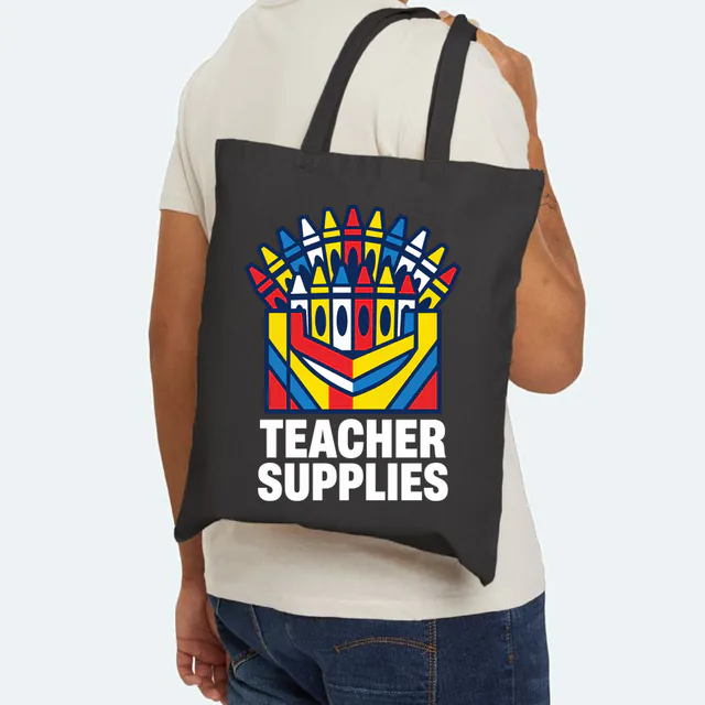 A fanned-out box of crayons, TEACHER SUPPLIES, on a black canvas tote