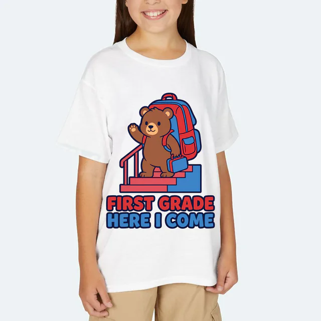 A waving bear cub with a lunchbox, FIRST GRADE HERE I COME, on a white youth t-shirt