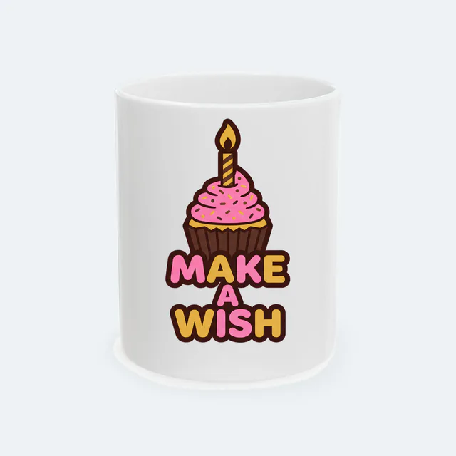 A cupcake with one candle, MAKE A WISH, on a white ceramic mug