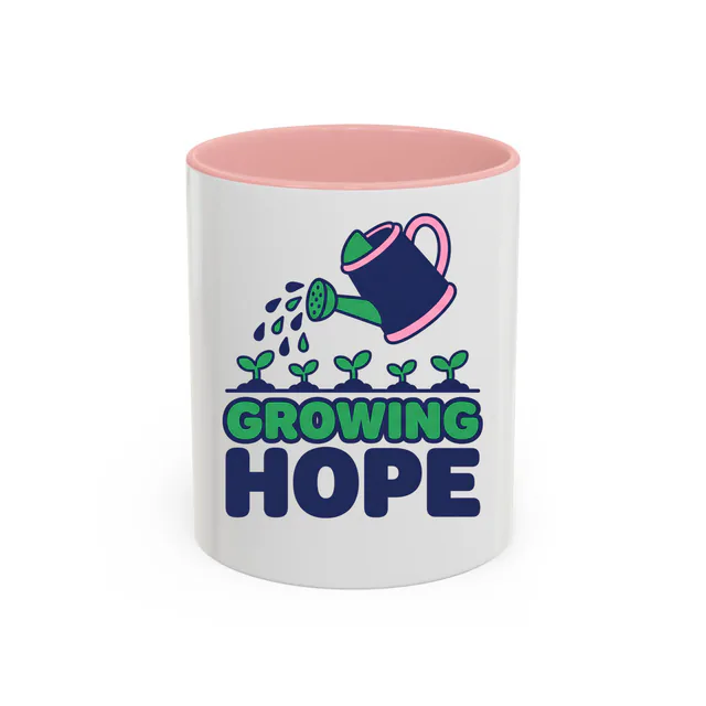 A watering can over little sprouts, GROWING HOPE, on a pink accent mug