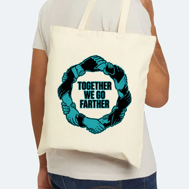 A circle of linked hands, TOGETHER WE GO FARTHER, on a natural canvas tote