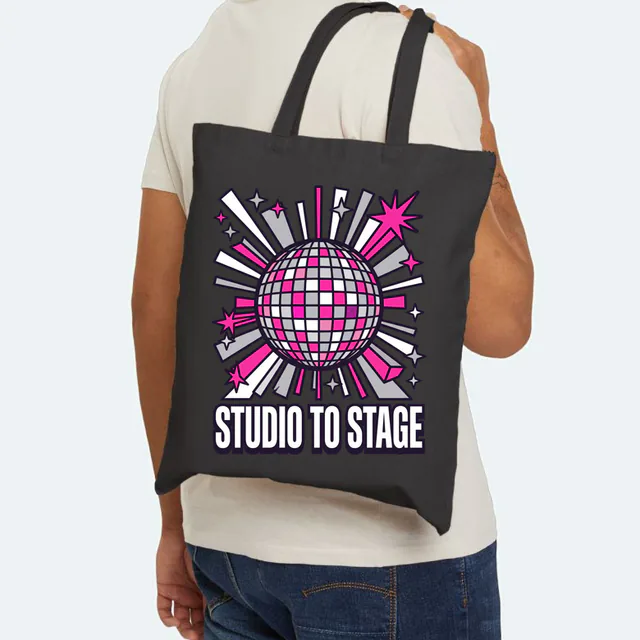 A sparkling disco ball, STUDIO TO STAGE, on a black canvas tote