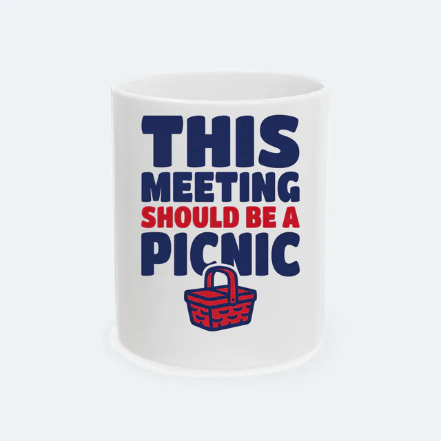 A wicker basket under THIS MEETING SHOULD BE A PICNIC, on a white ceramic mug