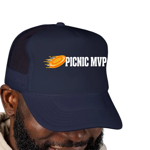 A flying disc in motion beside PICNIC MVP, on a navy foam trucker hat