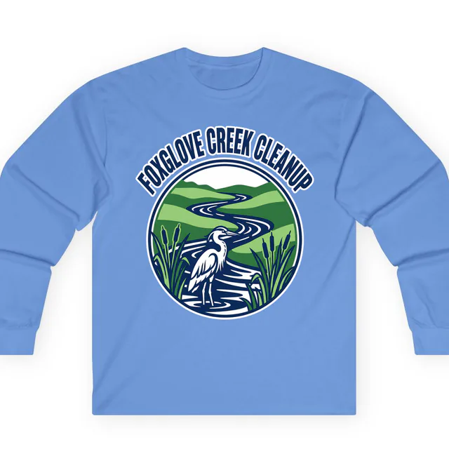 A heron in a winding river for the Foxglove Creek cleanup, on a carolina blue adult long sleeve