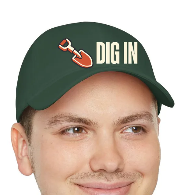 A garden shovel beside DIG IN, on a dark green dad hat
