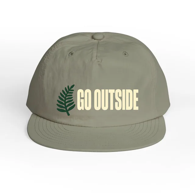 A fern frond beside GO OUTSIDE, on an eucalyptus surf cap