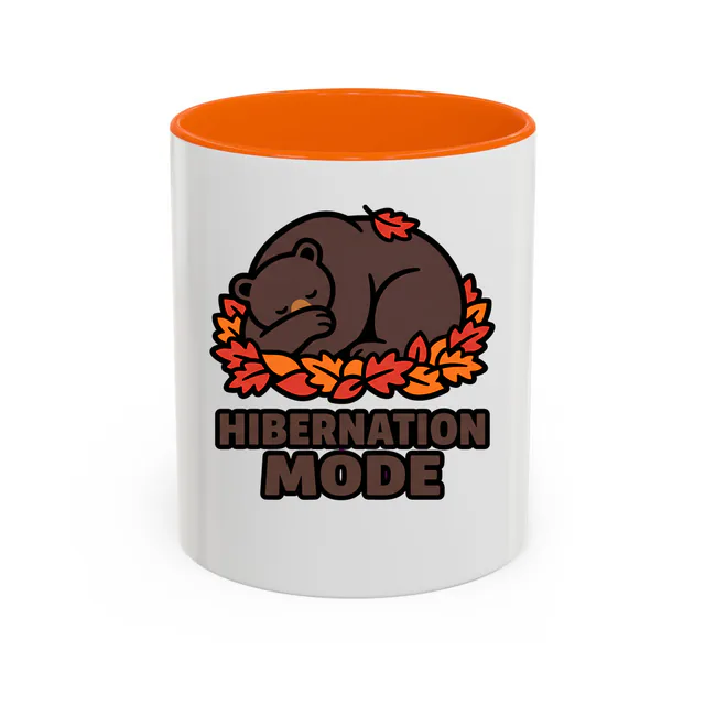 A sleepy bear in the leaves, HIBERNATION MODE, on an orange accent mug