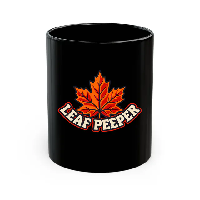 A big maple leaf over LEAF PEEPER, on a black mug