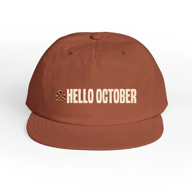 A tiny pinecone beside HELLO OCTOBER, on a clay surf cap