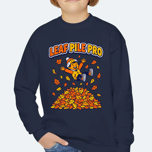 A kid leaping into a leaf pile, LEAF PILE PRO, on a navy youth crewneck
