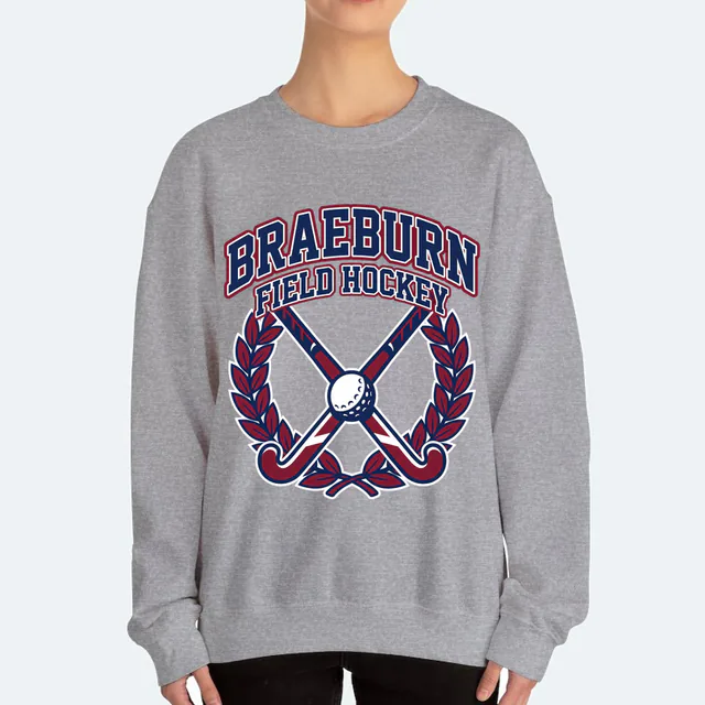 Crossed field hockey sticks in a laurel ring for Braeburn, on a sport gray adult crewneck