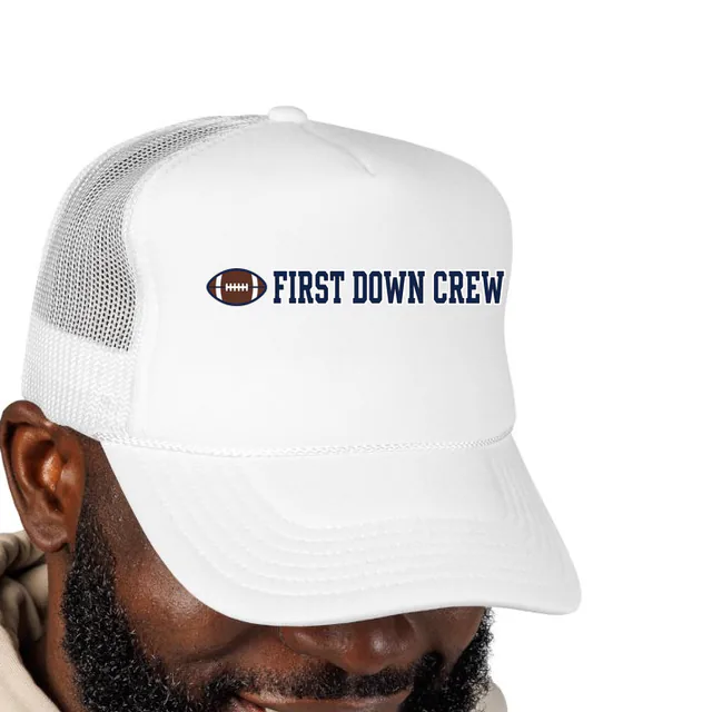 A laced football beside FIRST DOWN CREW, on a white foam trucker hat