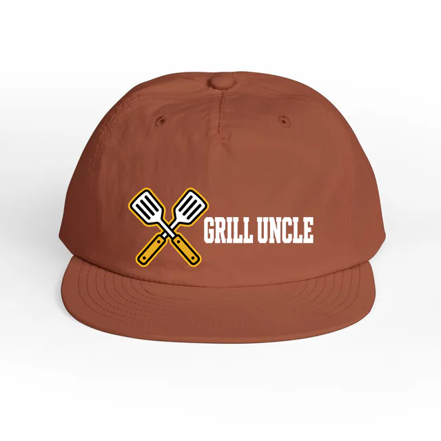 Crossed spatulas beside GRILL UNCLE, on a clay surf cap