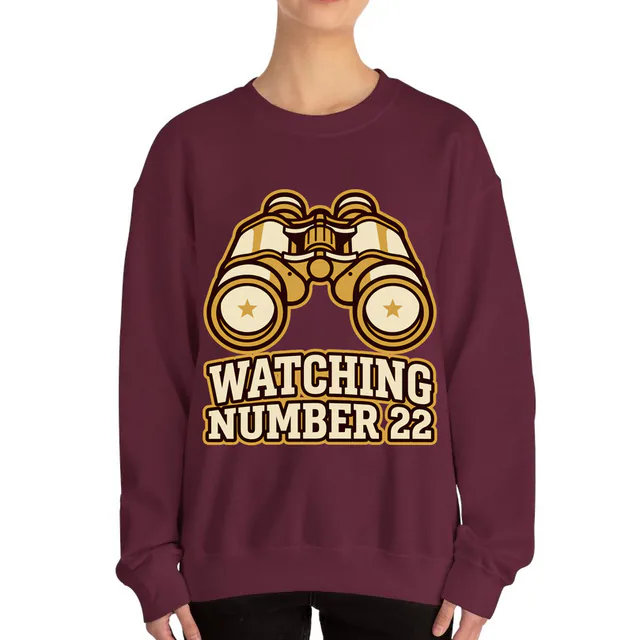 Vintage binoculars with stars in the lenses, WATCHING NUMBER 22, on a maroon adult crewneck