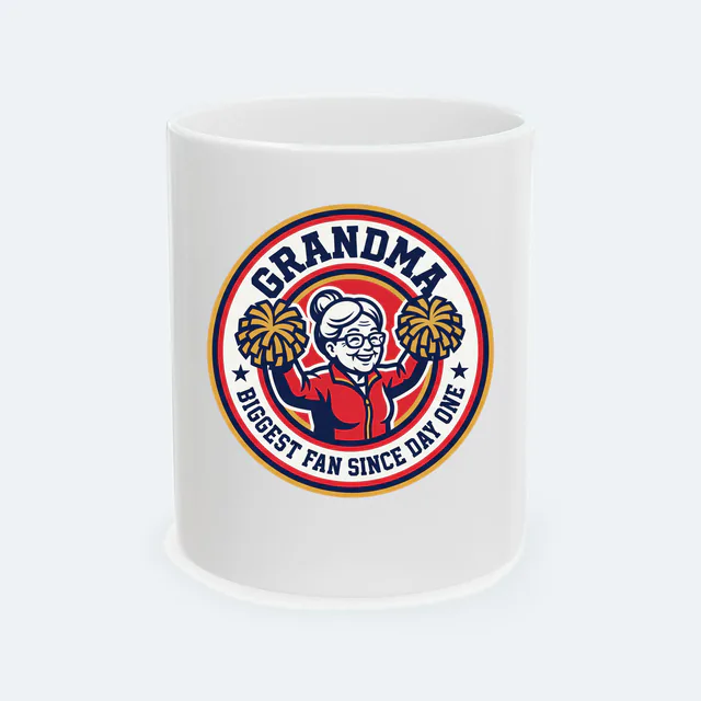 A cheering grandma with pom-poms, BIGGEST FAN SINCE DAY ONE, on a white ceramic mug