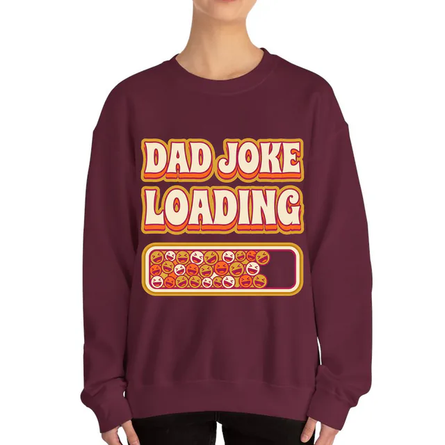 A progress bar of laughing faces, DAD JOKE LOADING, on a maroon adult crewneck