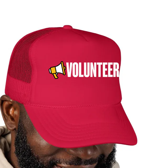 A megaphone beside VOLUNTEER, on a red foam trucker hat