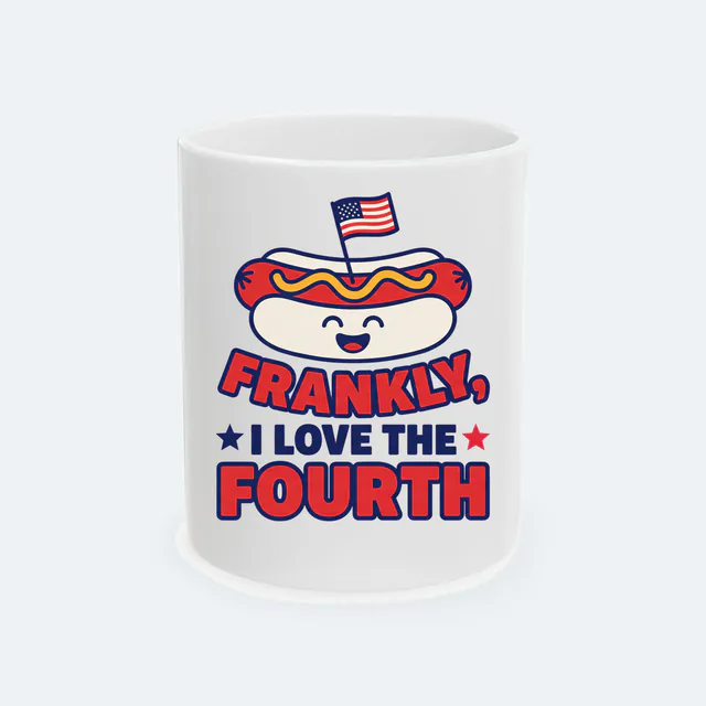 A hot dog with a flag pick, FRANKLY, I LOVE THE FOURTH, on a white ceramic mug