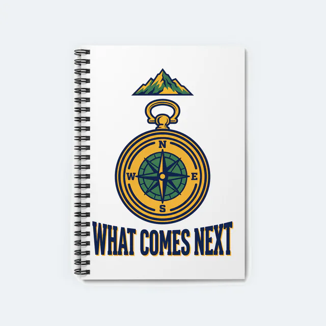 A compass pointing to a mountain peak, WHAT COMES NEXT, on a white spiral notebook