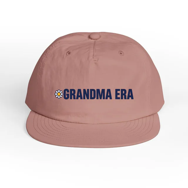A tiny daisy beside GRANDMA ERA, on a hazy pink surf cap