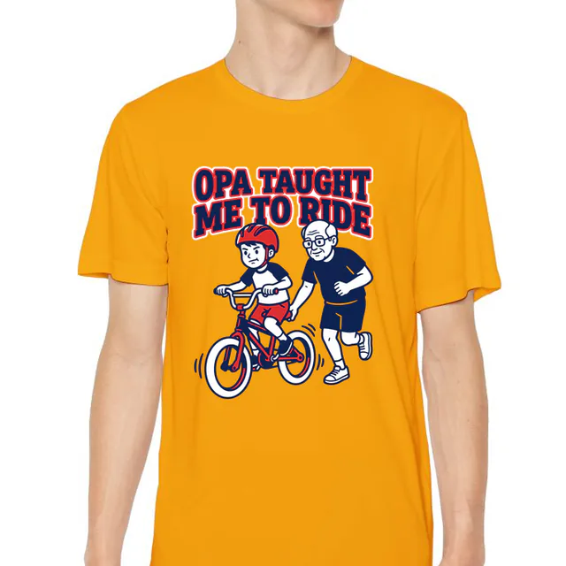 Grandpa jogging behind a wobbly bike, OPA TAUGHT ME TO RIDE, on a gold youth performance tee