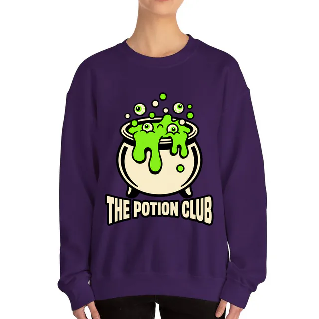 A bubbling cauldron of green potion for the Potion Club, on a purple adult crewneck