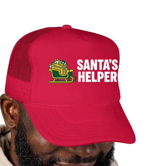 A sleigh full of gifts beside SANTA'S HELPER, on a red foam trucker hat