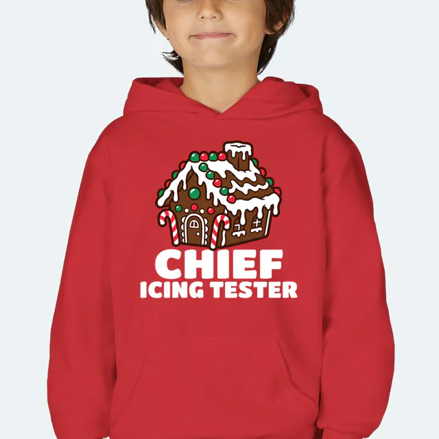 A gingerbread house over CHIEF ICING TESTER, on a red youth hoodie