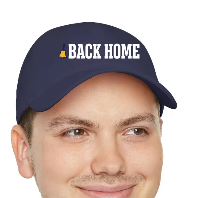 A tiny school bell beside BACK HOME, on a navy dad hat