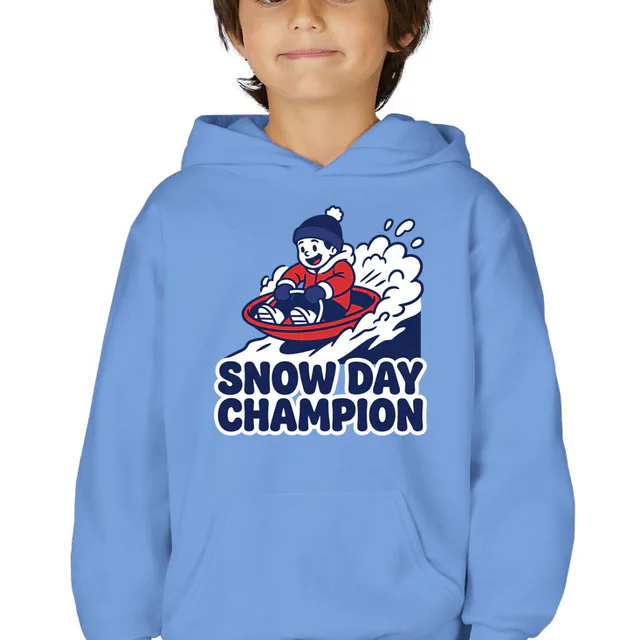 A kid racing downhill on a snow saucer, SNOW DAY CHAMPION, on a carolina blue youth hoodie