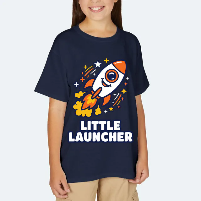 A smiling rocket zooming up on a trail of stars, LITTLE LAUNCHER, on a navy youth t-shirt