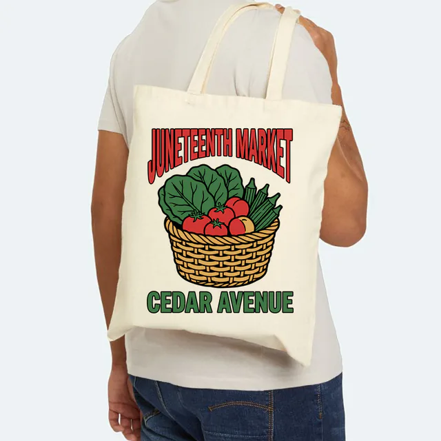 A basket of greens and peaches for the Juneteenth market, on a natural canvas tote