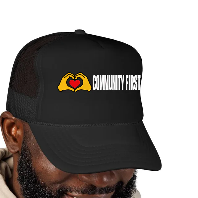 Two hands making a heart beside COMMUNITY FIRST, on a black foam trucker hat