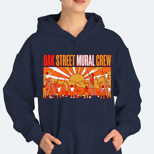 Volunteers painting a sunrise mural, OAK STREET MURAL CREW, on a navy adult hoodie