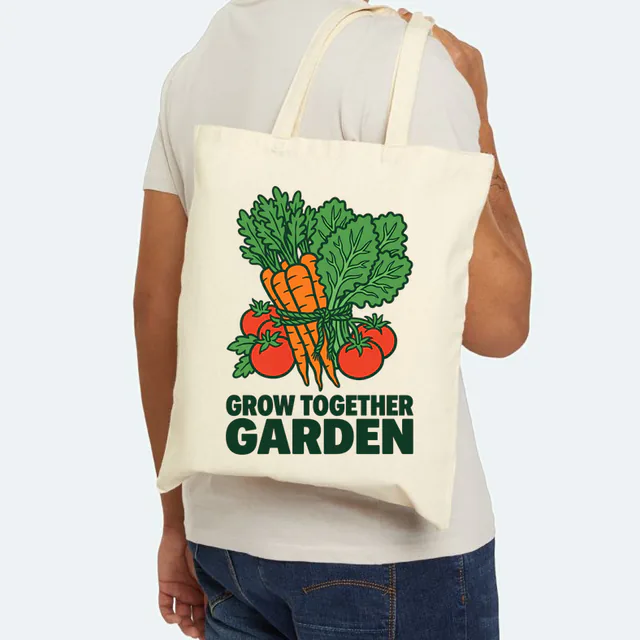 A tied bunch of garden vegetables, GROW TOGETHER GARDEN, on a natural canvas tote