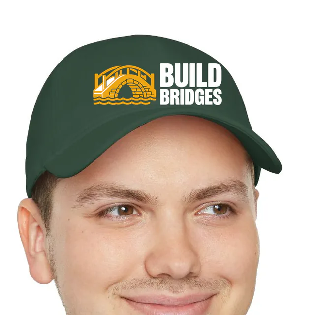 A little arched bridge beside BUILD BRIDGES, on a dark green dad hat
