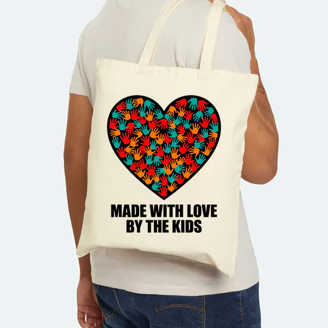 A heart full of little handprints, MADE WITH LOVE BY THE KIDS, on a natural canvas tote