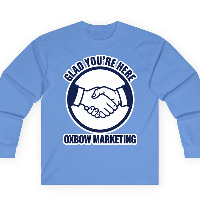 A handshake in a circle, GLAD YOU'RE HERE, on a carolina blue adult long sleeve