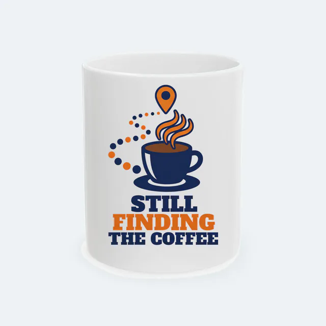 A map pin over a steaming coffee, STILL FINDING THE COFFEE, on a white ceramic mug