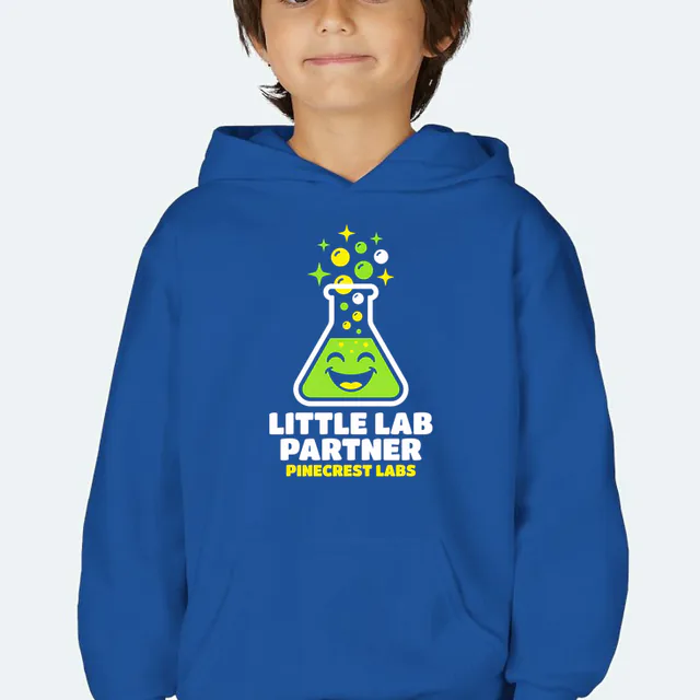 A smiling bubbling beaker, LITTLE LAB PARTNER, on a royal youth hoodie