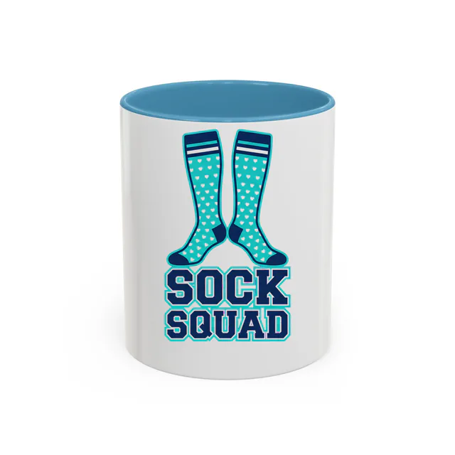 Heart-covered compression socks, SOCK SQUAD, on a light blue accent mug