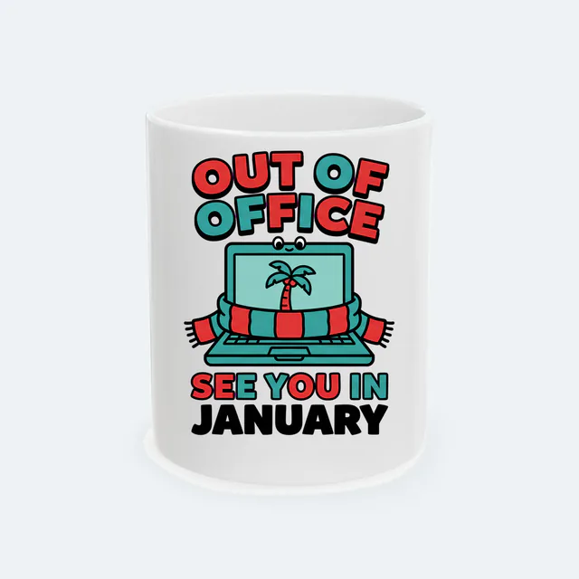 A laptop in a scarf, OUT OF OFFICE, SEE YOU IN JANUARY, on a white ceramic mug
