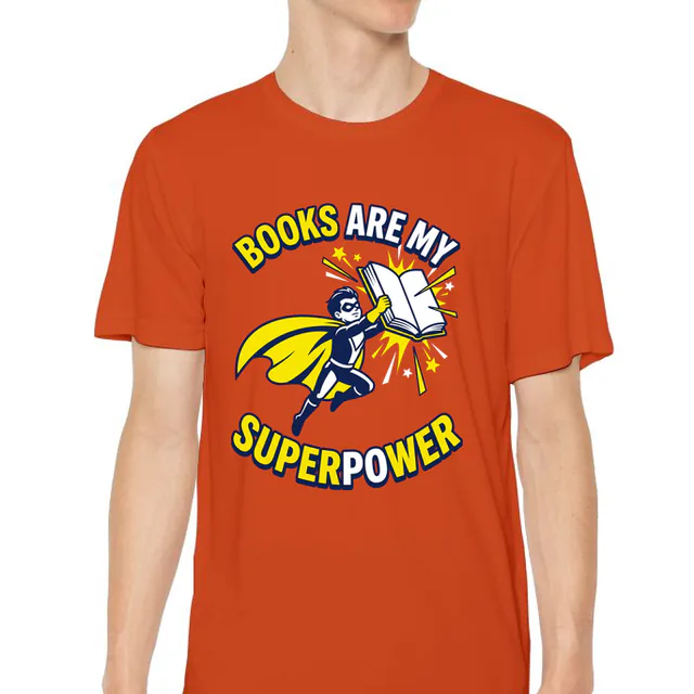 A caped kid soaring with an open book, BOOKS ARE MY SUPERPOWER, on an orange youth performance tee
