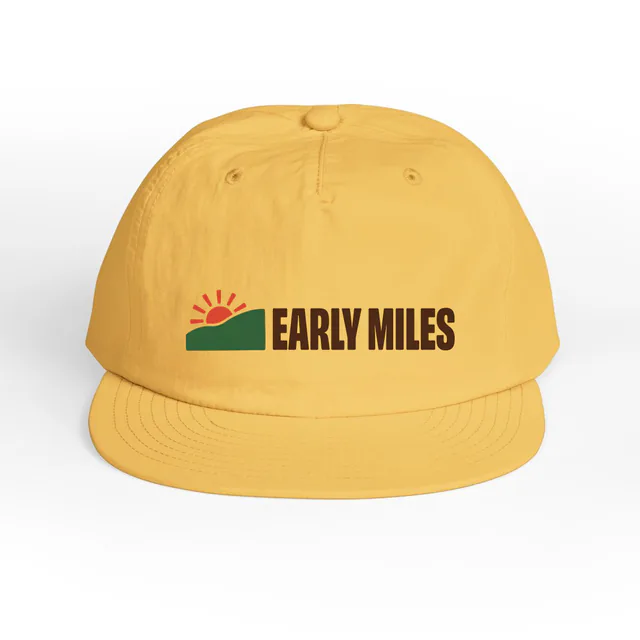 A sun peeking over a hill, EARLY MILES, on a sunset surf cap