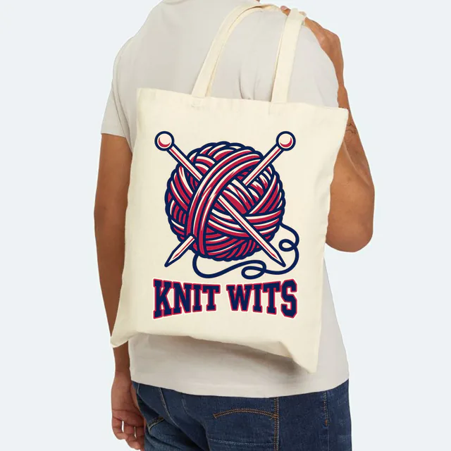A ball of yarn with crossed needles, KNIT WITS, on a natural canvas tote