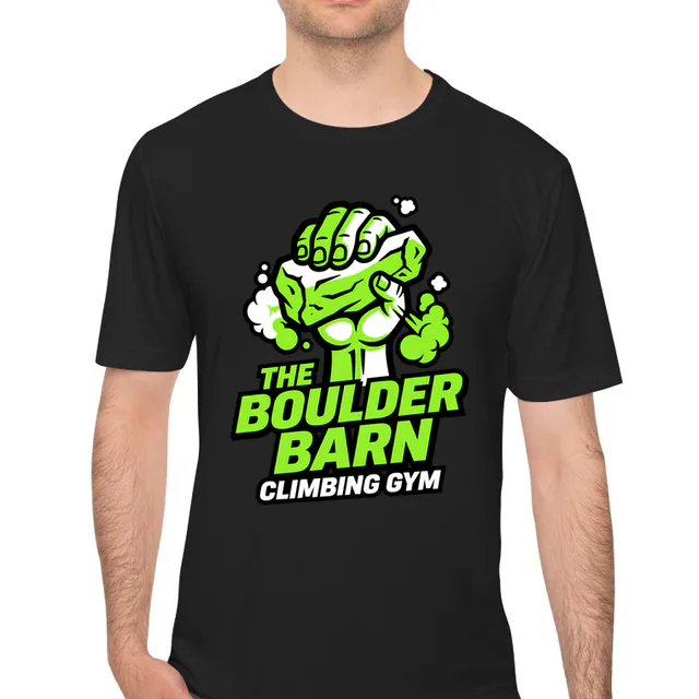 A hand gripping a climbing hold, THE BOULDER BARN, on a black performance tee