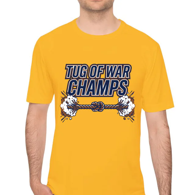 A rope pulled tight with dust flying, TUG OF WAR CHAMPS, on a gold performance tee